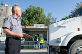Security guard inspecting industrial truck.